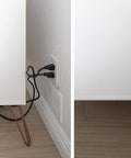 Ultra Thin Outlet Concealer Kit with Flat Extension Cord Power Strip installed, hiding cords and outlets in a living room corner.