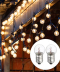 Twelve Piece Pack E10 Miniature Screw Base Light Bulbs 4.8 Volt 2.4 Watt Warm Yellow Glow shown with string lights.