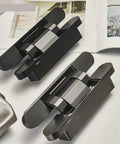 Heavy Hitter Ball Bearing Door Hinges Featuring 180 Degree Swivel Motion Invisible Hydraulic Build For Kitchen Cabinets And Folding Doors Super Smooth Action And Tough Black Build Quality on a table.