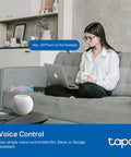 Rock Solid Outdoor Smart Plug With Dual Independently Controlled Outlets And Hella Reliable IP65 Weather Resistance For Seamless Matter Compatible Smart Home Automation And Voice Control in a home setting with a woman using voice control.