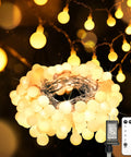Warm White 33Ft 100 LED Connectable Globe String Lights With Remote for Bedroom, coiled with warm glow, remote shown