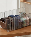 Top Shelf Crystal Clear Acrylic Belt Organizer With Removable Dividers Stackable Storage Bin for ties and watches on wooden surface.