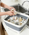 Collapsible Dish Basin With Drain Plug 2.4 Gal Foldable Sink For Kitchen RV Camping And Dorm, filled with baby bottles being washed.