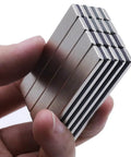 Heavy Duty Badass Neodymium Bar Magnets, 24 Pack Rare Earth Kickass Adhesive Backing held in hand, showing size and shape.