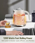 1.7L Electric Kettle With Stainless Steel Interior, BPA-Free, Cordless on desk next to hand holding cup, 1200W Fast Boil