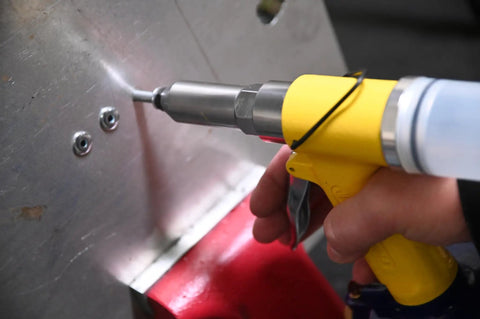 Person using air riveter with quick change nosepieces for 3/32 inch through 1/4 inch capacity on metal surface