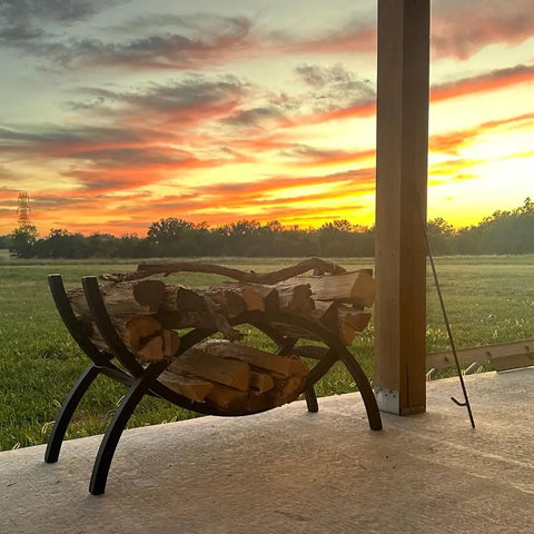 3 Foot Crescent Firewood Rack Heavy Duty Indoor Outdoor Steel Log Holder With Black Powder Coat Finish on patio at sunset