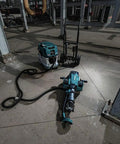 Badass Heavy Duty Eighty Volt Brushless Cordless Breaker Hammer With Seventy Foot Pounds Of Knockout Chisel Power And One One Eighth Inch Hex Shank Avt Anti Vibration Aws Compatible Demolition Kit Featuring Four Massive Eight Amp Hour Packs For Concrete on a worksite.