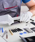 Technician using Badass Mini Phillips Screwdriver Set Four Millimeter Cross Heads for smartphone repair on a table.