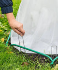 Person securing landscape fabric with Heavy Duty 6 Inch U Shaped Landscape Staples Pack Of 50 For Weed Barrier Fabric And Landscape Fabric And Lawn Edging Galvanized Steel Ground Pins For Strong Hold In Garden And Yard