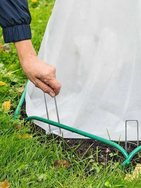 Person securing landscape fabric with Heavy Duty 6 Inch U Shaped Landscape Staples Pack Of 50 For Weed Barrier Fabric And Landscape Fabric And Lawn Edging Galvanized Steel Ground Pins For Strong Hold In Garden And Yard
