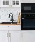 Solid Brass Cabinet Pull And Drawer Knob With Modern Grooved Base Design in kitchen setting on white cabinets