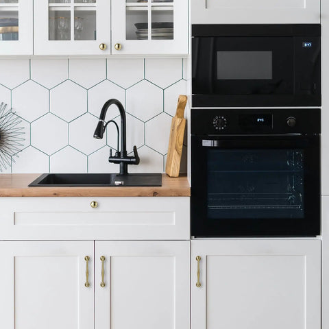 Solid Brass Cabinet Pull And Drawer Knob With Modern Grooved Base Design in kitchen setting on white cabinets