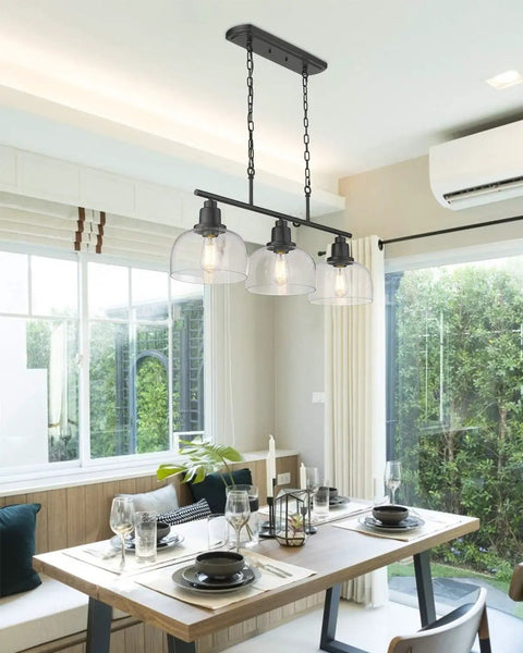 Three Light Farmhouse Kitchen Island Pendant Chandelier, 35.4 in Long, Black Finish With Seeded Bubble Glass above dining table.