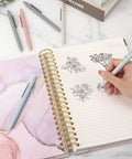 Pack Of Six Smooth Writing Retractable Gel Pens Featuring Snappy Click Mechanism And Fast Drying Black Ink That Rolls Dead Smooth Across Pages Ideal For Classroom Assignments Desk Organization And Daily Note Taking Without Any Smudging on a notebook with sketches.