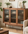 Stylish cabinet with three glass doors, wooden frame, and gold accents, ideal for living room or storage.