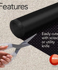 Black Embossed Diamond Plate Pattern Floor Runner Protector, 27 Inches Wide By 25 Feet Long, shown being cut with scissors