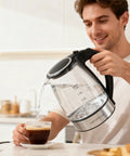 Man pouring water from Electric Glass Kettle With Auto Shut Off 1.8L Borosilicate Glass Body Stainless Steel Inner Lid And Base