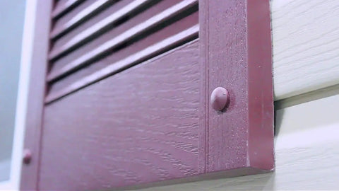 Close-up of Premium Heavy Duty Vinyl Shutter Fastener Spike Lok Anchors on dark gray vinyl shutters affixed to siding.