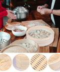 Two Tier Bamboo Food Steamer Basket For Dumplings And Fresh Seafood With No Sweat Cleanup in a kitchen setting with prepared dumplings.