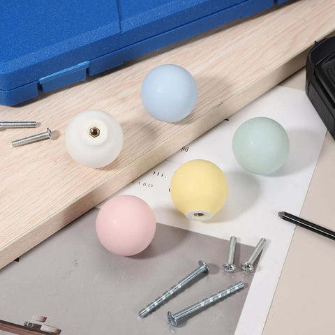 Top Shelf 2-Pack Bright Yellow Ceramic Cabinet Knobs, Smooth 1.3 Inch Round Drawer Pulls With Fast Install Screws For Kitchen Cabinets Dressers Closets Nursery Room DIY Renovation Hardware on a wooden surface with screws.