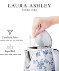 Hand opening a floral patterned electric kettle with removable limescale filter and rapid boil feature.