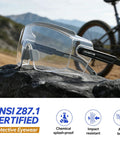 Dual Pack Anti Fog Safety Glasses Built Tough To Slide Snugly Over Your Daily Specs While Delivering Brite Vision And Ansi Z87 Compliance For Hardcore Shop Jobs And Weekend Fixes resting on a rock with a mountain backdrop.
