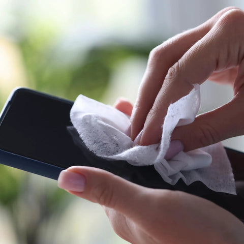 Hands using 70 Percent Isopropyl Alcohol Wipes For Your Electronics And Screens, 80 Count Per Pack In Sealed Canister to clean smartphone.