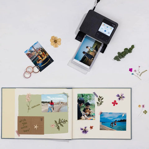 Selphy CP1500 Photo Printer Bundle Wireless Dye Sub Kit with 108 Sheets KP-108 Paper, Three Ink Cartridges, and Tudak Cleaning Cloth shown with a printed photo and scrapbook.