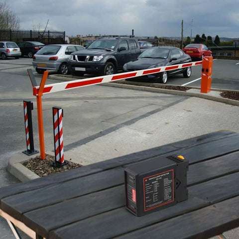 Pro Grade Vehicle Loop Detector for Automatic Doors and Parking Gates with sensitivity controls on a table near gate.