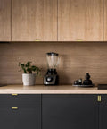 Modern kitchen featuring Premium Gold Cabinet Handles Finger Edge Pulls on black cabinetry and a blender on wooden countertop.
