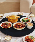 Smooth As Butter Black Tempered Glass Lazy Susan Turntable Built Different Heavy Duty Rotating Serving Tray For Dining Tables with assorted dishes.