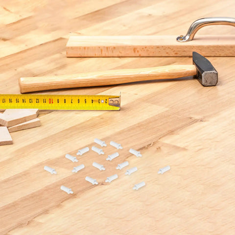 White Shutter Repair Pins, 120 Piece Movable Louver Fasteners on a wooden surface with a tape measure and hammer.