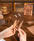Hands assembling Gothic Architecture 3D Puzzle Kit For Adults With LED Lights Wooden Model Building Set on a wooden table
