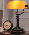 Bankers Desk Lamp With USB Port, Dope Rustic Oil Rubbed Bronze Finish, Pull Chain Desk Light With Amber Yellow Glass Shade, Vintage Home Office Library Accent Lamp For Reading And Task Lighting on a desk with a clock and cup.