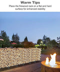 Eight Foot Outdoor Firewood Rack Holder With Fourteen Support Legs for firewood storage near a lit fire pit at dusk.
