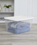 Built Tough 58 Quart Clear Plastic Storage Bin With Zero Sweat Snap Lock Lid, holding folded blue blankets for organized storage.