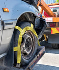 Heavy Duty Tow Dolly Basket Straps Two Pack With Flat Steel Hooks For 15 To 19 Inch Car Tires on a tire, securing it for transport.