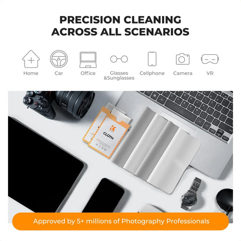 Two white microfiber lens cleaning cloths with orange striped packaging cards beside a camera and laptop.