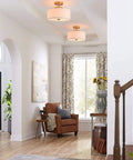 13 Inch Mid Century Modern Flush Mount Ceiling Light With Cream White Fabric Shade And Antique Brass Finish 3 Light Drum Fixture For Bedroom Dining Room Foyer And Kitchen shown installed in a living room.