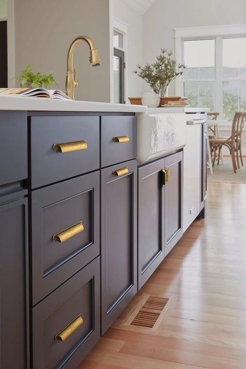 Six Pack Antique Brass Cabinet Cup Pulls Three Inch Center To Center Spacing on kitchen drawers with dark finish.