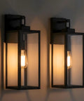 Top Tier 2 Pack Outdoor Wall Lanterns Standout With Heavy Duty 18 Inch Build And Foolproof Dusk To Dawn Photocell Sensor To Keep Your Porch Garage And Patio Lighting Effortlessly Bright From Sunup To Sundown, featuring black aluminum sconces with clear glass.