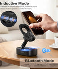 Person placing smartphone on foldable Wireless Induction Speaker Phone Stand With Bluetooth Audio Amplifier, on a table.