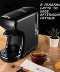 Compact Capsule Coffee Machine With Built In Grinder And Steam Wand For Home Or Office on a wooden countertop with a cup of coffee.