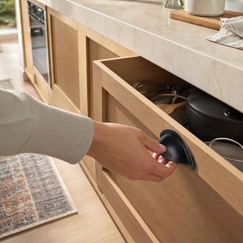 Person using Twelve Pack 2.5 Inch Matte Black Cup Pull Cabinet Handles Built Tough Zinc Alloy Drawer Hardware on kitchen drawer.
