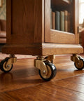Solid Brass Furniture Casters on a wooden cabinet, showcasing antique style smooth rolling wheels for easy mobility.
