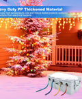 Heavy Duty Weatherproof Outdoor Electrical Box And Extension Cord Cover With Six Rugged Cable Ports built next to a snowy Christmas tree.
