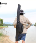 Angler carrying Lightweight Nylon Rod And Reel Case That Stashes 2 To 3 Poles With Reels Folded About Six Inches by a lake