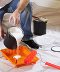 Top Shelf Rubber Textured Paint Roller With Kick Butt Spiked Surface For Walls Floors And Furniture Refinishing Creates A Hella Cool Pro Level Diy Look The Rugged Metal Core Rocks Through Thick Textures Like Brick Or Shiplap Without Tearing Up Drywall So pouring white paint from a black can into an orange tray beside a textured paint roller.
