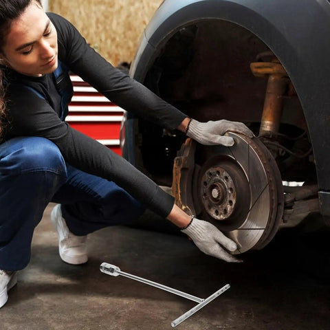 A person using a Straight Shooter T Handle Socket Wrench Set Forged From Heavy Duty Steel To Crack Open Stubborn Nuts And Bolts Without Breaking A Sweat on a car wheel.